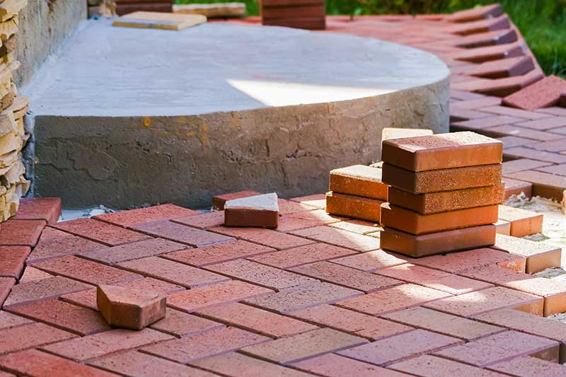 shutterstock_1701689065 clay brick patios, masonry brick patios - Brown clinker paving stones for laying paths in the garden