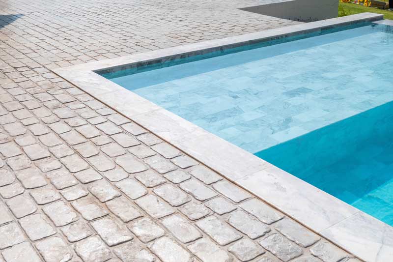 shutterstock_1701689065 masonry pool decks stone pool surrounds concrete pool decks