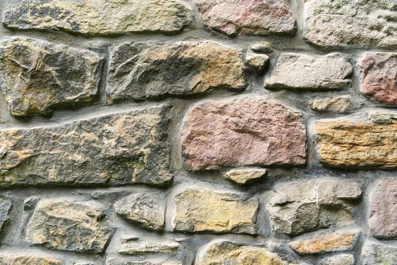shutterstock_1701689065 mortared stone wall construction